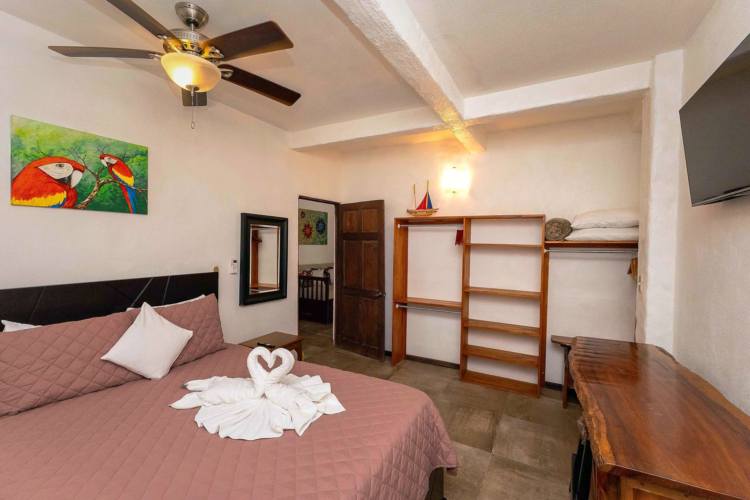 Habitación con pintura de lapas rojas y escritorio