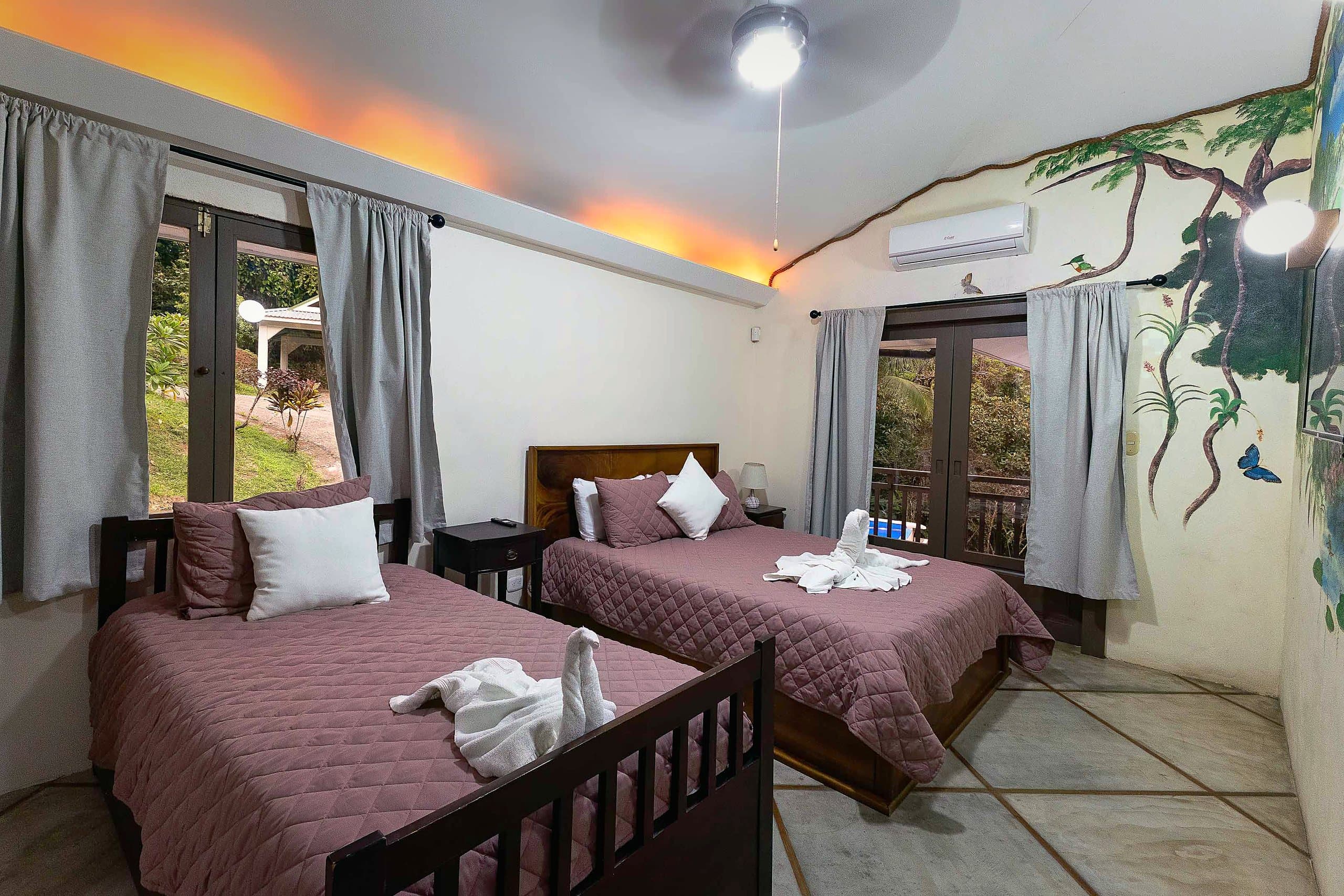 Habitación con mural de selva y dos camas